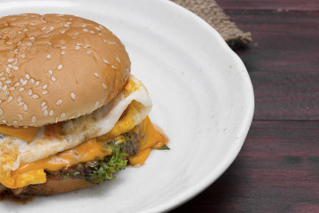 hamburger in plate on wood table.