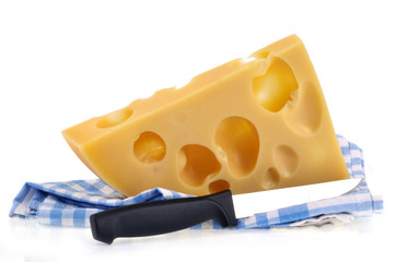 Morceau d'emmental posé sur un torchon avec un couteau