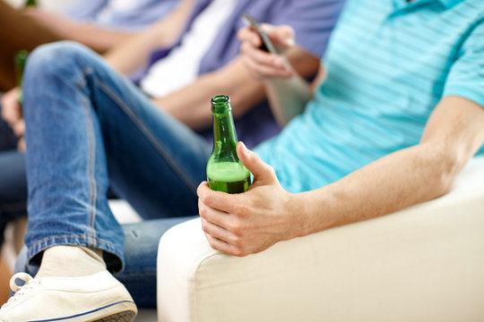 Close Up Of Male Friends Drinking Beer At Home