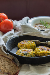 Healthy vegetarian patties made from potatoes, carrots, onions, and green on a background of tomato sauce, selective focus.
