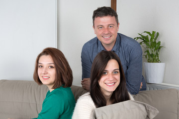 Happy family of three watching TV together at home