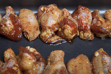 Marinated chicken wings on a black pan