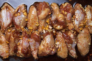 Marinated chicken wings on a black pan