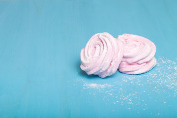 Fresh pink homemade zephyr - marshmallow on blue wooden table. T