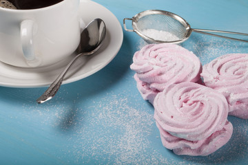 Fresh pink homemade zephyr - marshmallow and white cup of tea on