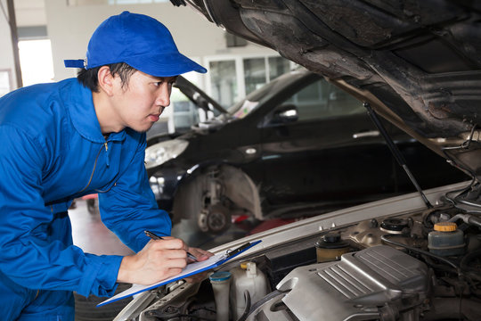 Man in blue technician uniform going to repair for car maintenance