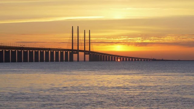 Oresundsbron at sunset. The bridge between Sweden and Denmark. Cars drive over the bridge
