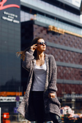 Fototapeta premium Beautiful girl in a cardigan, shirt and sunglasses outdoor