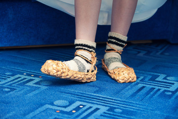 Russian bast shoes on a blue carpet