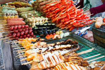 Fototapeta premium Meatballs and seafood on sticks at a market in Bangkok, Thailan