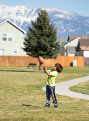 Young boy catching football.