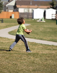 Young boy catching football.