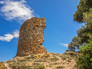Ancient half-ruined watchtower on blue sky background