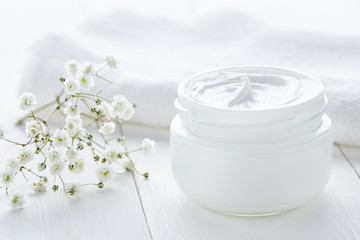 Fototapeta na wymiar Yogurt cream beauty cosmetic product wellness and relaxation makeup mask in glass jar with towel on white background