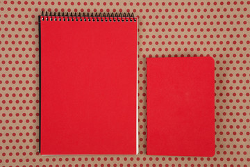  desk accessories - two red notepads on craft  paper background