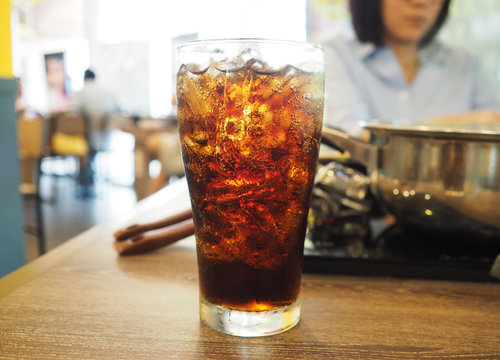 glass of cola with ice  on dining table