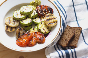 grilled vegetables in a plate and two slices of brown bread