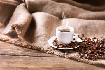 Cup of coffee with sackcloth on table close-up