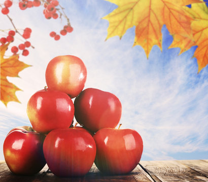Heap of red apples on table on sky background