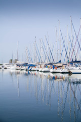 Obraz premium Reflection of yacht masts in the water 