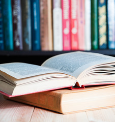 Open book on table  bookshelves background