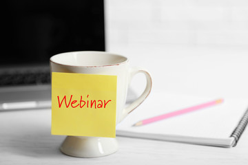 A cup with sticky note on the office table, close up