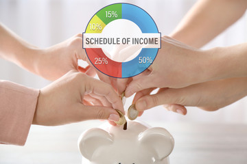 Business accounting concept. Hands putting coin into piggy bank at the table