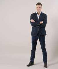 full length portrait of handsome businessman standing in suit on