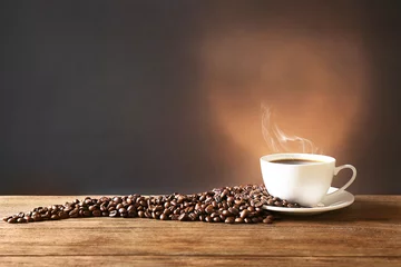 Foto op Plexiglas Koffiebar Kopje koffie op tafel op bruine achtergrond