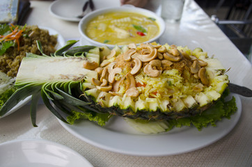 pineapple curry fried rices shot on Thai restaurant table with other Thai foods background