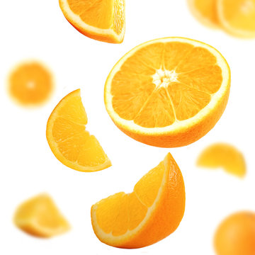 Falling ripe oranges isolated on white