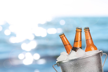 Bierflaschen kaltes frisches Bier im Eiskübel, auf Meer- oder Ozeanhintergrund