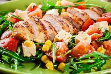 Fresh salad with chicken breast, arugula and tomato