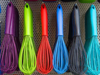 Bunte Schneebesen an der Wand, mit Haken befestigt