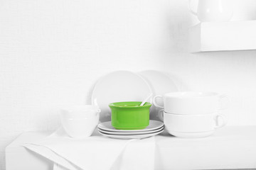 Fototapeta na wymiar Set of tableware with napkin on shelf against white wall background