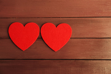 Obraz na płótnie Canvas Red felt hearts on purple wooden background