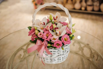 Fototapeta na wymiar beautiful pink bouquet of mixed flowers in basket on table