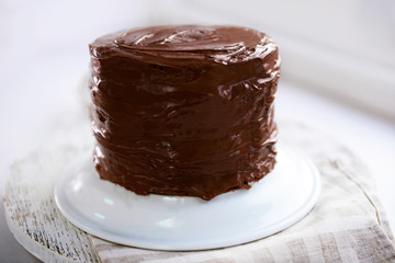 Chocolate cake on a plate on unfocused background