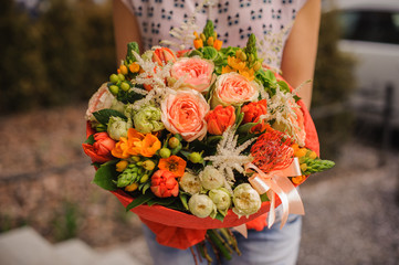 Bouquet of the different  orange flowers in hands - Powered by Adobe