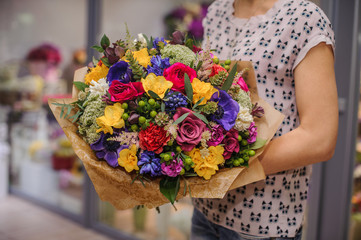 colorful bouquet  with different flowers in hands