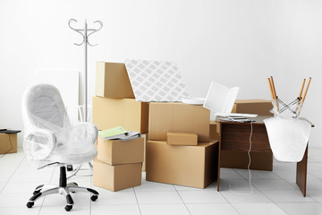 Moving cardboard boxes and personal belongings in empty office space