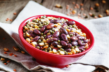 Bean mix: purple beans, green and red lentils, dry peas in a red