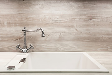 Modern designer chrome water tap over stainless steel kitchen sink.