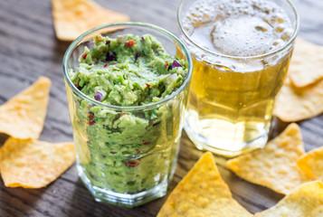 Guacamole with tortilla chips and glass of beer