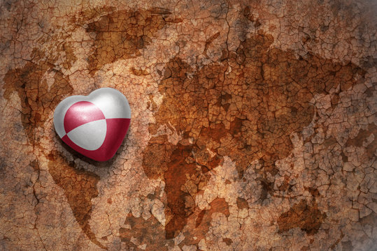 heart with national flag of greenland on a vintage world map crack paper background. concept
