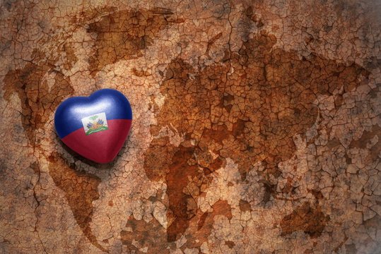 heart with national flag of haiti on a vintage world map crack paper background. concept