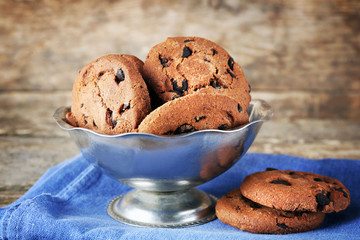 Chocolate chip cookies in a metal bowl on wooden table