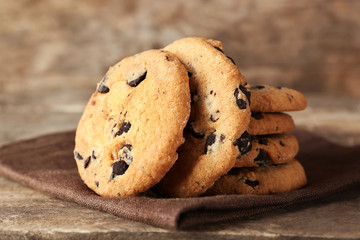 Chocolate chip cookies on a brown napkin on wooden table