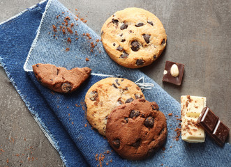 Chocolate chip cookies on a jeans napkin on dark grey background