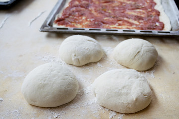 pastry board rolling pin and dough balls to make the tomato sauc